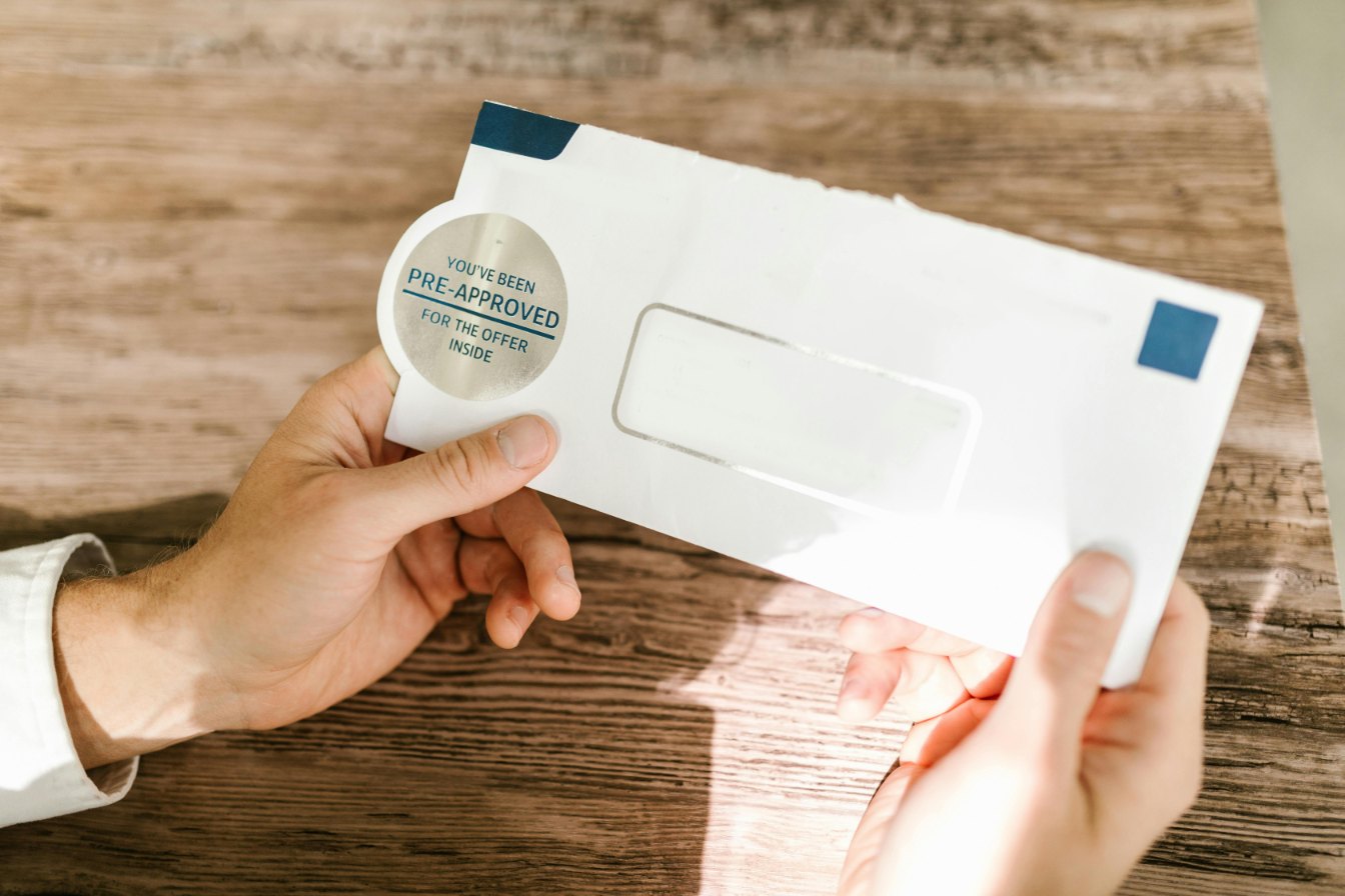 A philatelist using specialized tongs to lift a perfectly preserved stamp from a solvent bath in a dusty, book-lined archive.