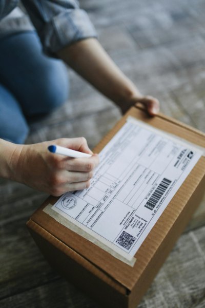 A professional woman in a modern Charlotte law office, meticulously organiz-in' rolls of 2023 US Flag Forever stamps into a climate-controlled storage bin to prevent adhesive degradation.