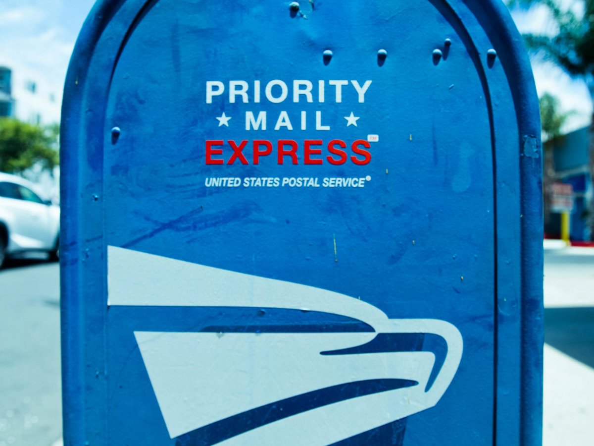 An insurance agent in Columbus signing policy renewal notices and applying official flag stamps to improve customer retention.