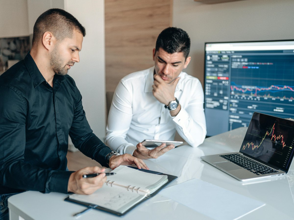 A tax prep office manager reviewing a cost-per-unit spreadsheet for a forever stamp pack comparison involving 100, 500, and 1000 piece orders.