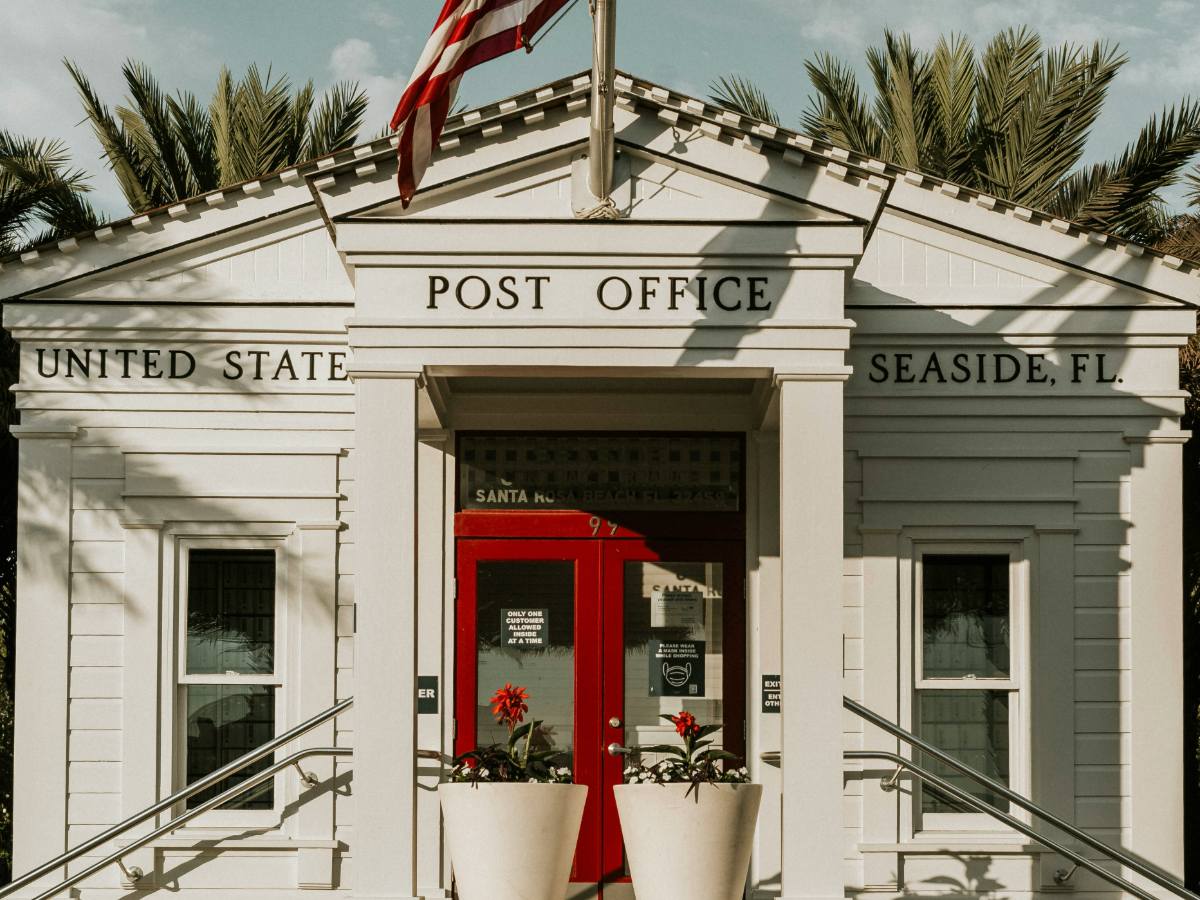 A Seattle e-commerce founder in her office auditing a batch of VCP bundles and applying additional ounce stamps from a professional coil with the city skyline in the background.